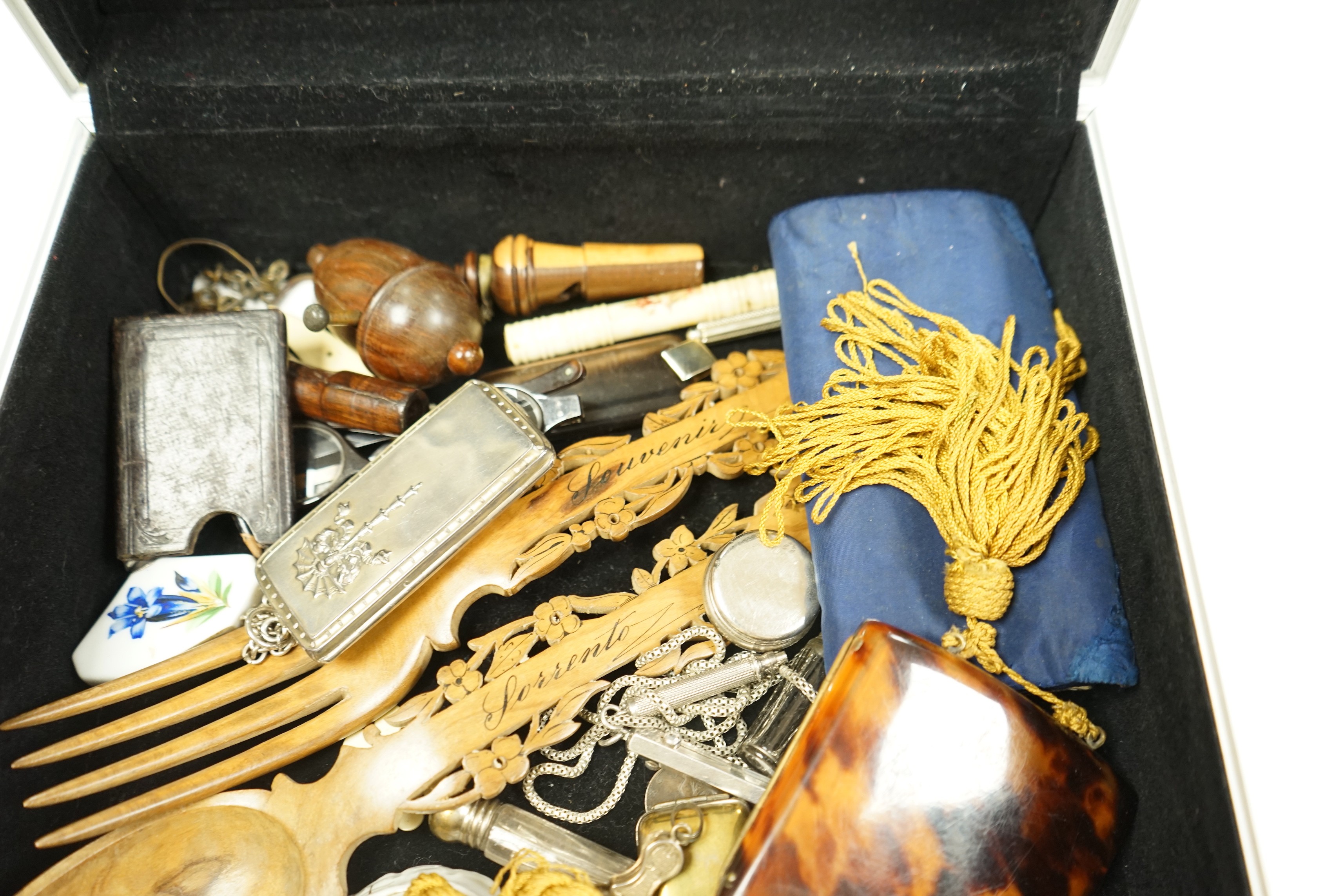 A metal case containing mixed collectibles including treen whistles, a cigarette case, three white metal propelling pencils etc